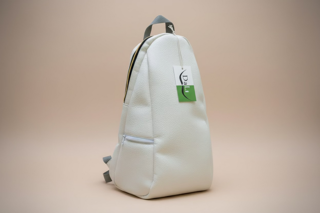 White backpack with a green label on a wooden bench in a park