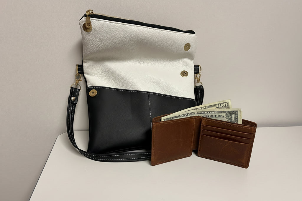 Two-tone handbag with a black and white design, open wallet with money on a light gray background