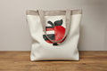 Tote bag with a red and black abstract design on a wooden surface