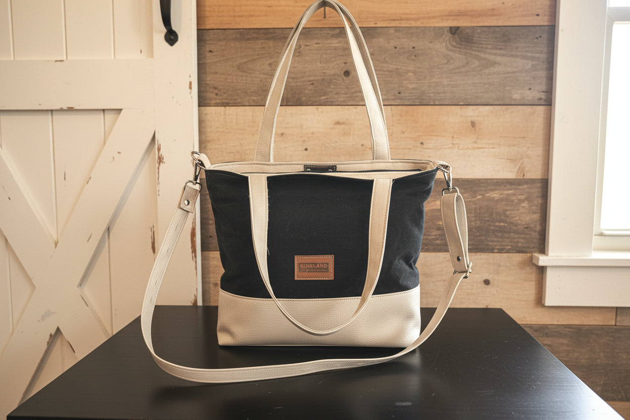 Two-toned handbag with black and beige design on a wooden surface.