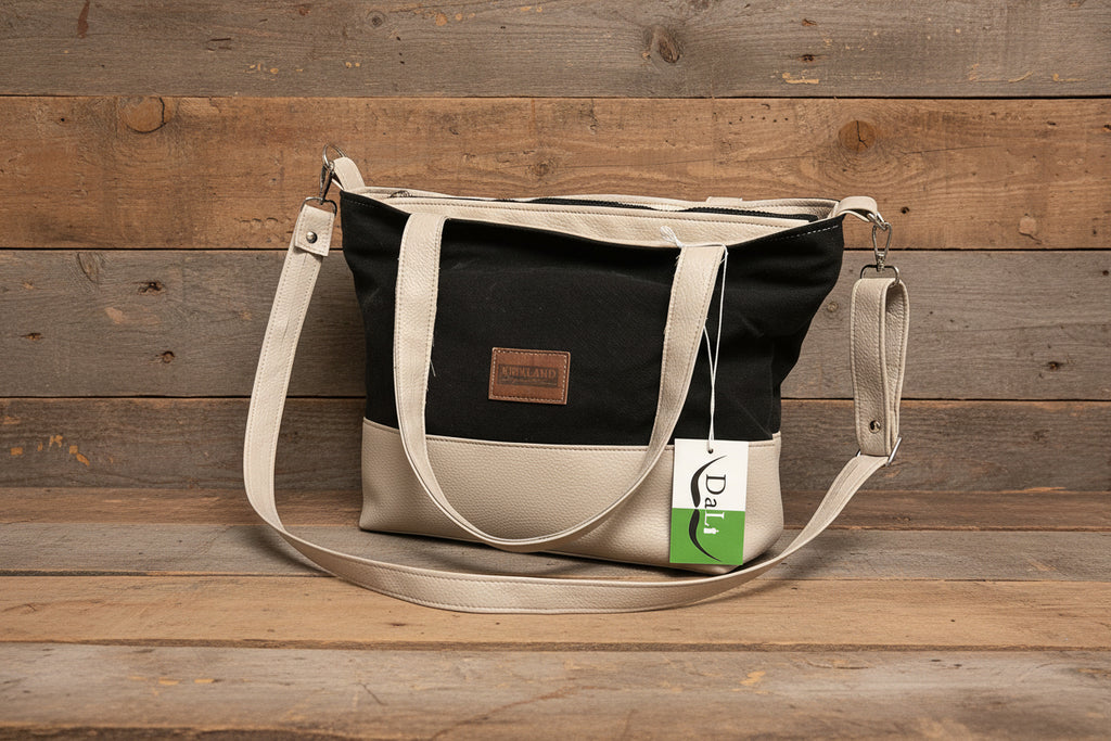 Black and beige handbag with a visible brand tag on a wooden surface
