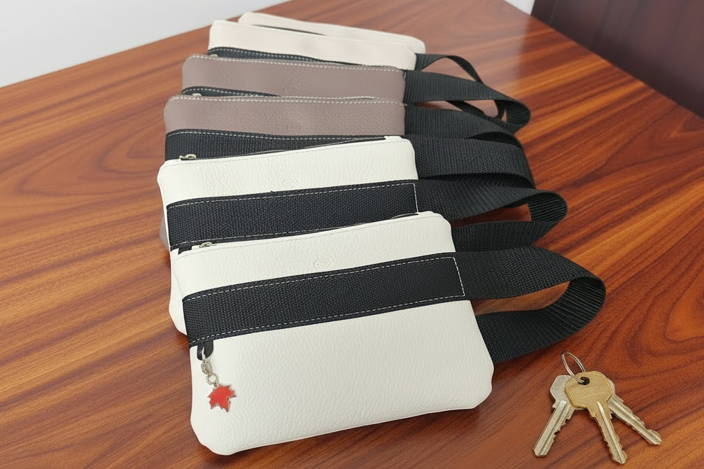 Multiple wrist bags with black straps on a wooden surface, with keys beside them.