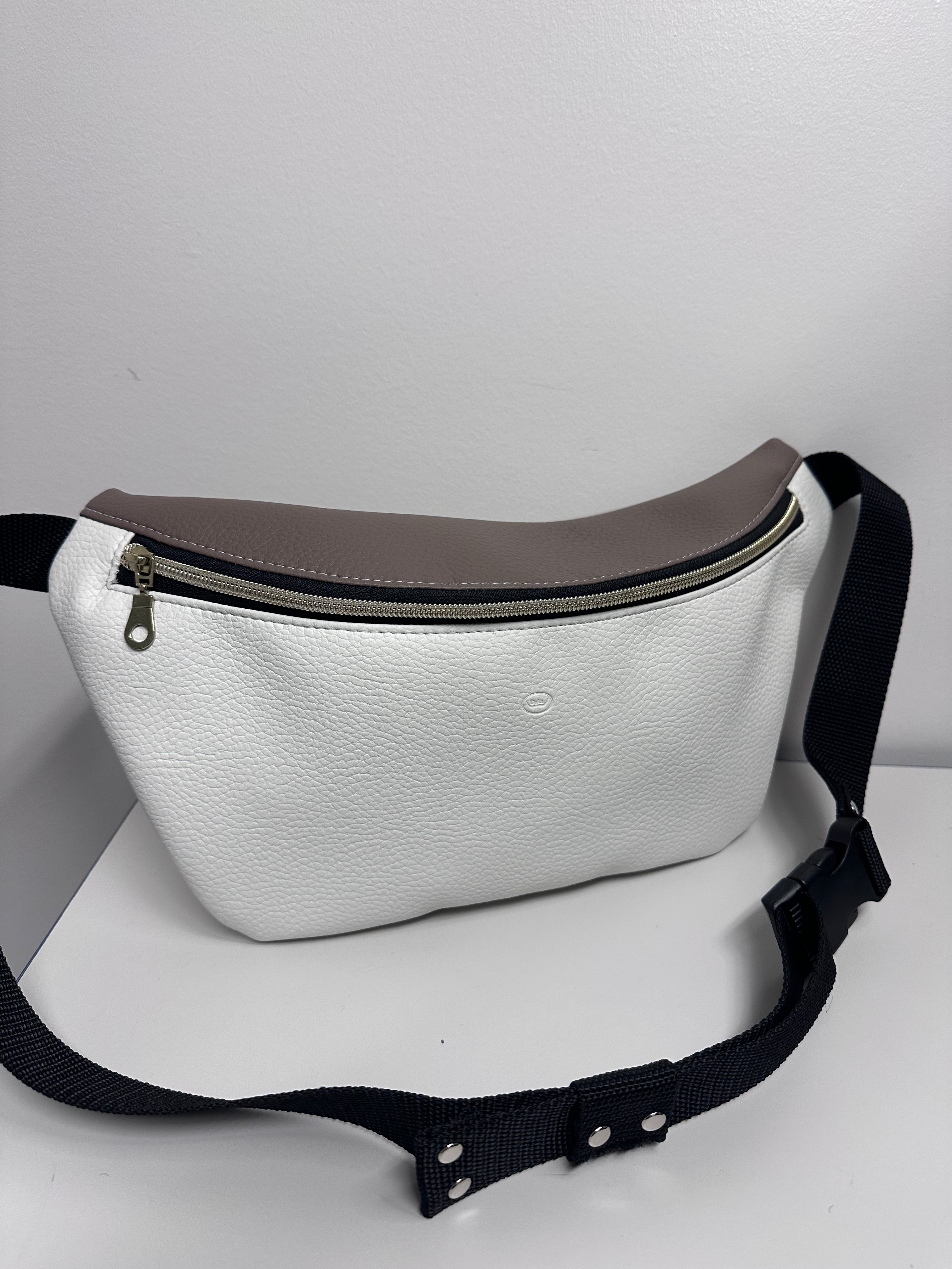 White waist bag with a black strap on a white background