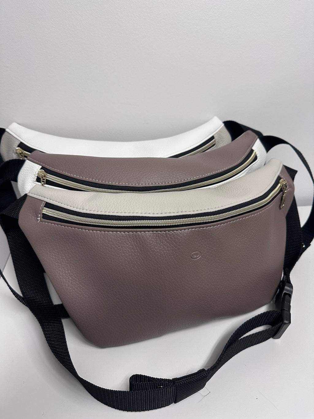 Three waist bags in white, gray, and brown on a light gray background