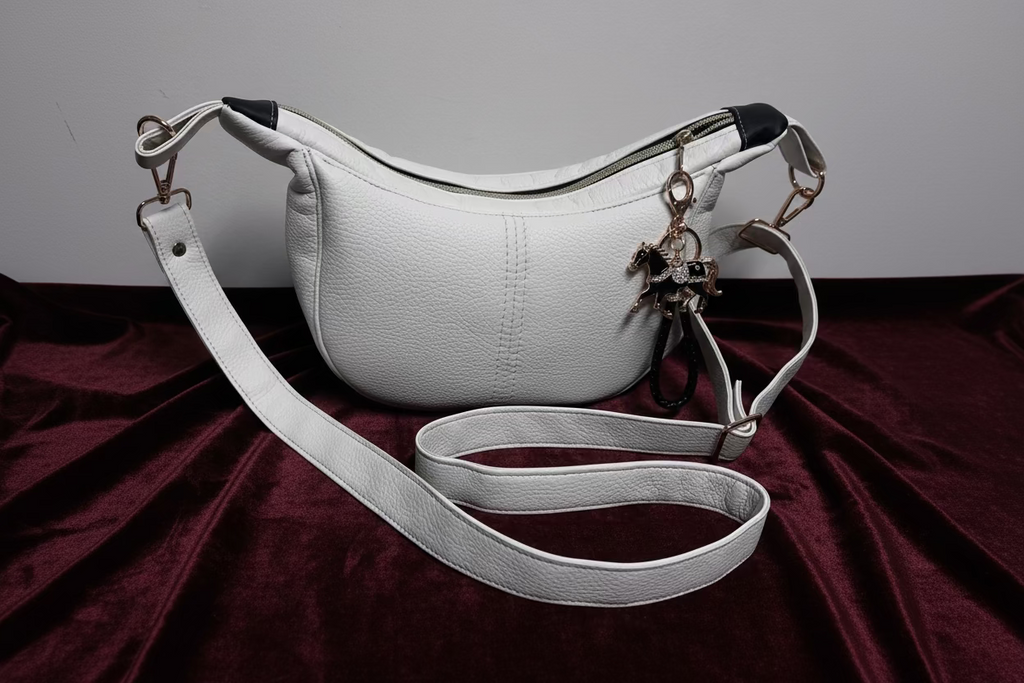 White handbag with a strap on a gray background