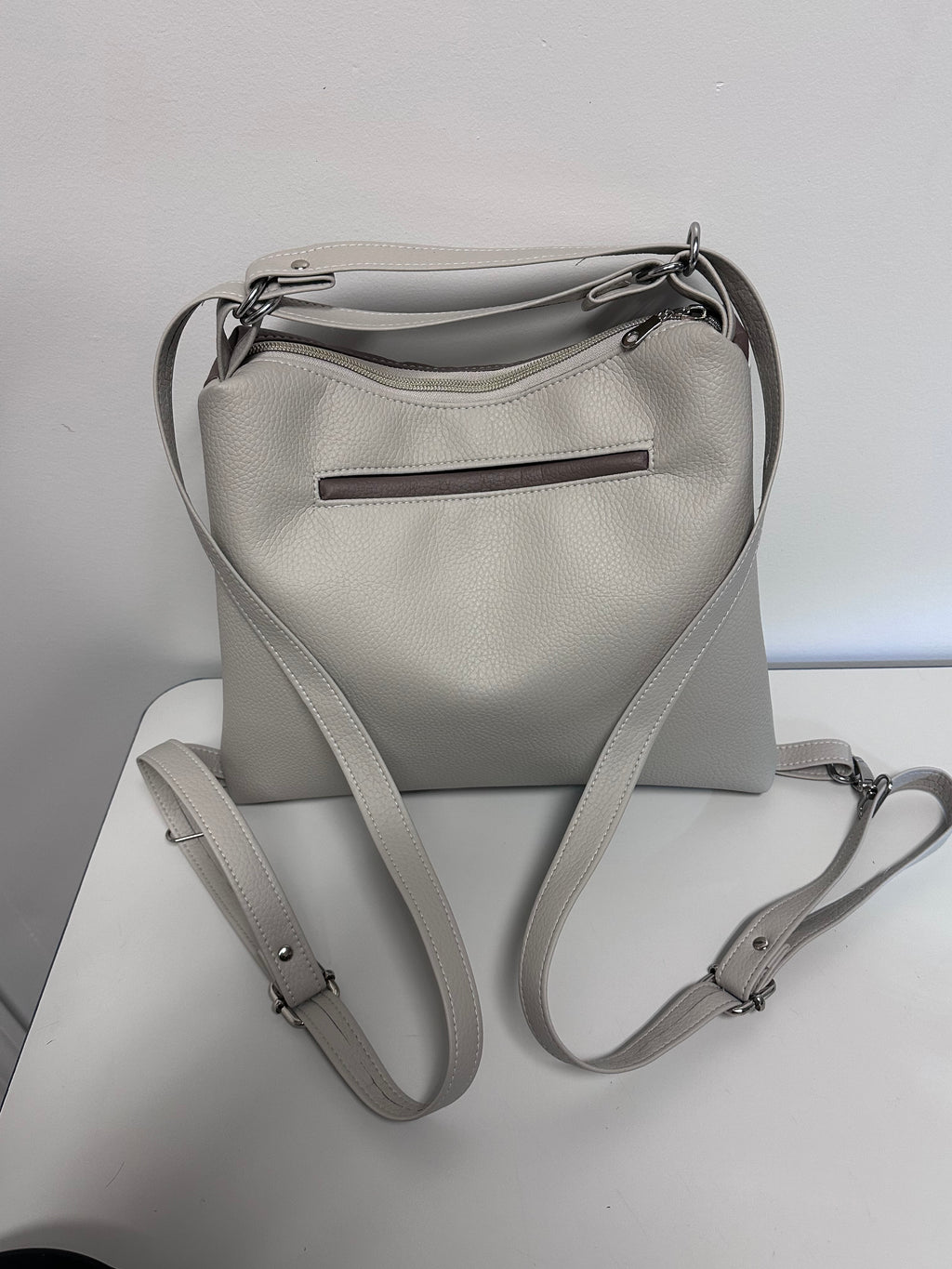 Gray faux leather backpack on a light gray background