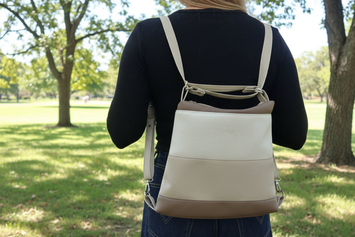 Girl wearing a beige and brown backpack in a park setting