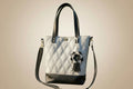 White handbag with black accents and a decorative flower on a light gray background
