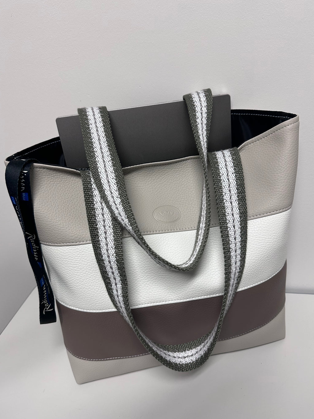Gray and white sandal with a decorative strap on a gray background