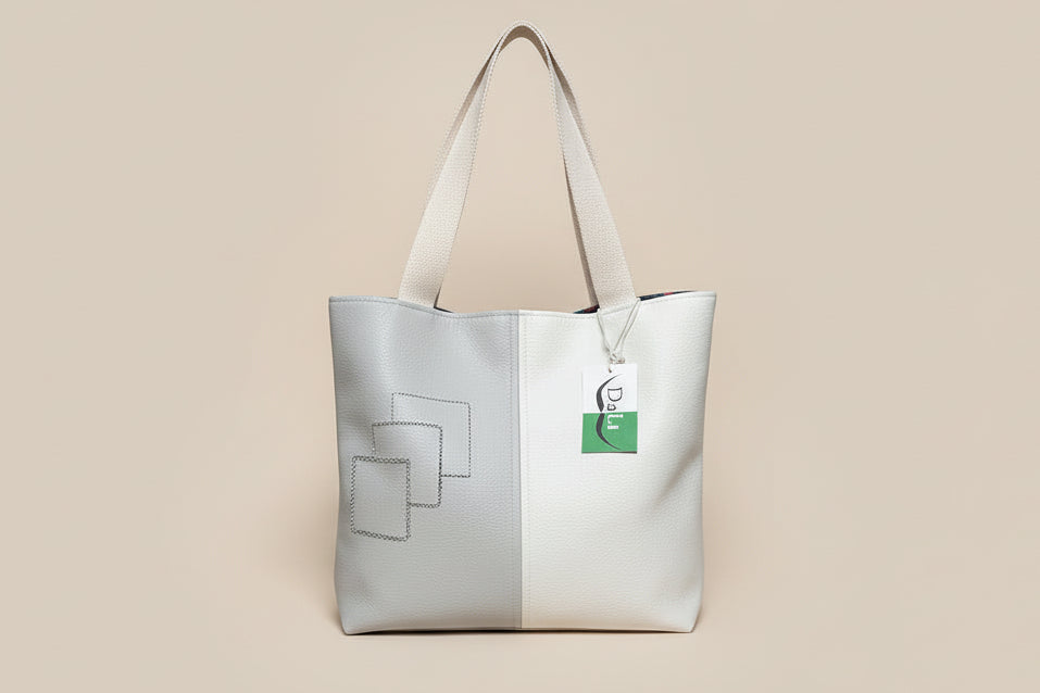 Gray tote bag with a logo, water bottle, and tablet on a gray surface