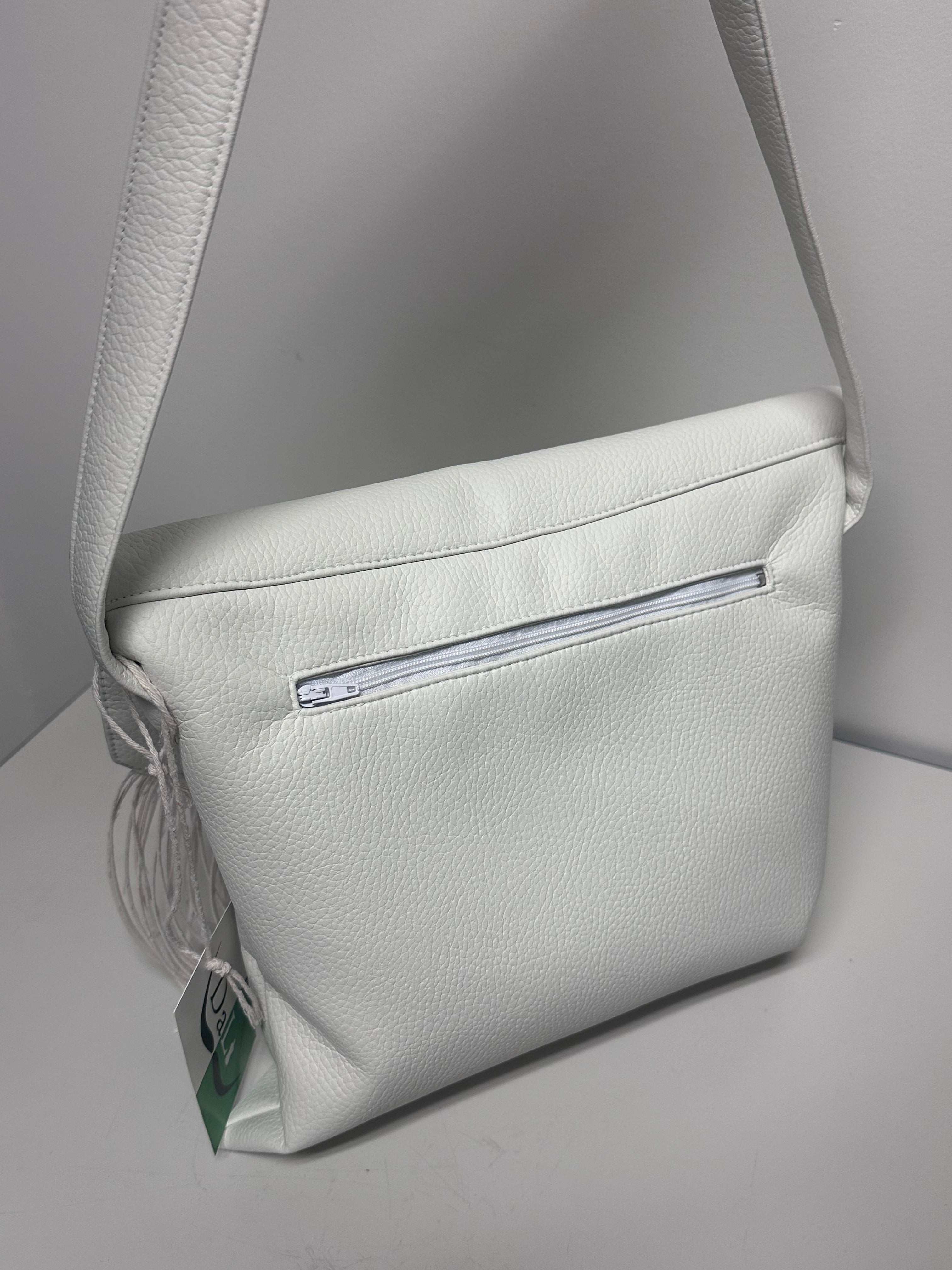 White faux leather handbag with a visible brand label on a light gray background