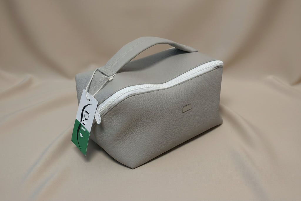 Gray pouch with a white zipper on a light gray background, featuring a Dali tag.