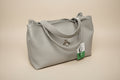 Gray handbag with a bee charm on a light gray background