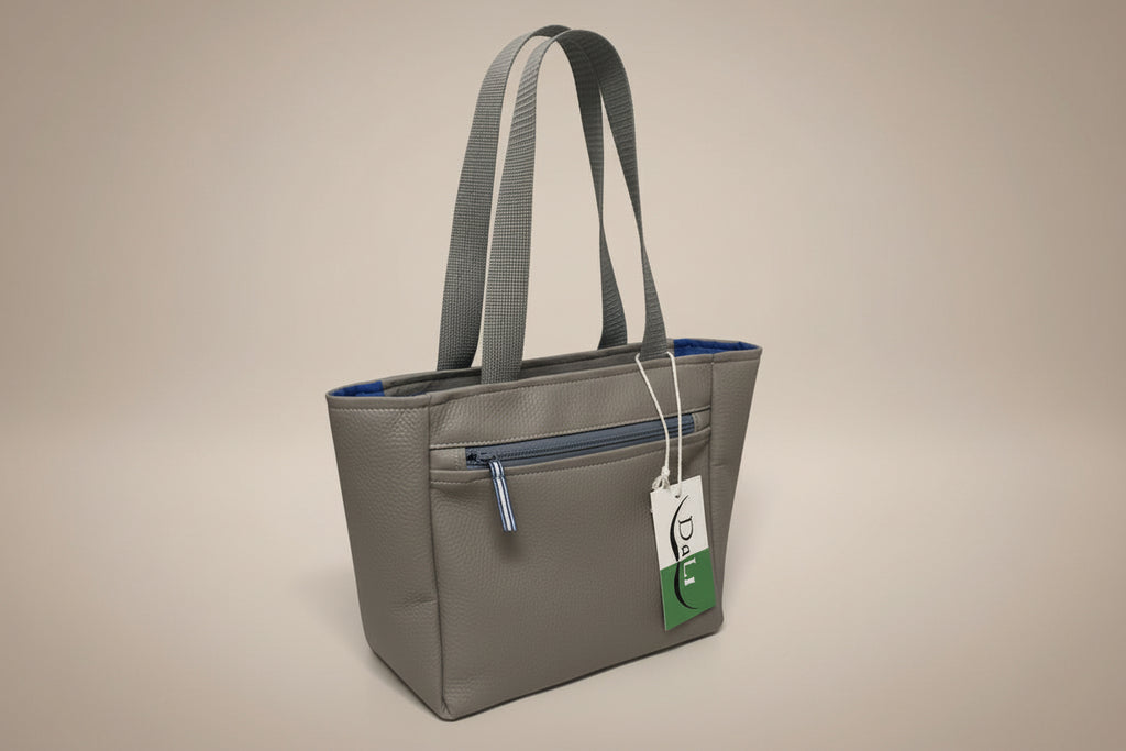 Gray tote bag with a blue interior held by a hand on a light gray background