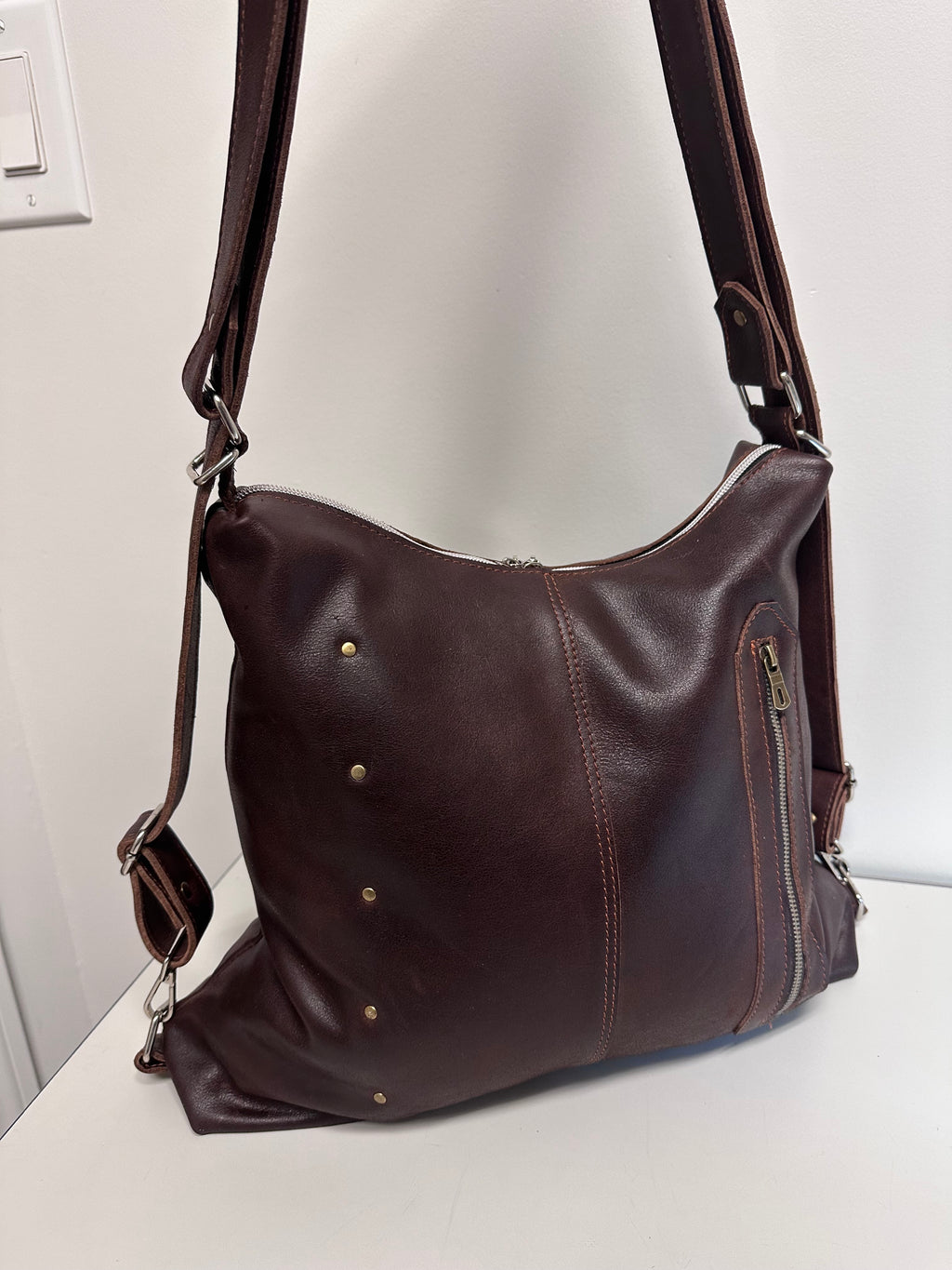 Brown leather handbag on a white surface