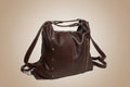 Brown leather bag with straps on a light gray background