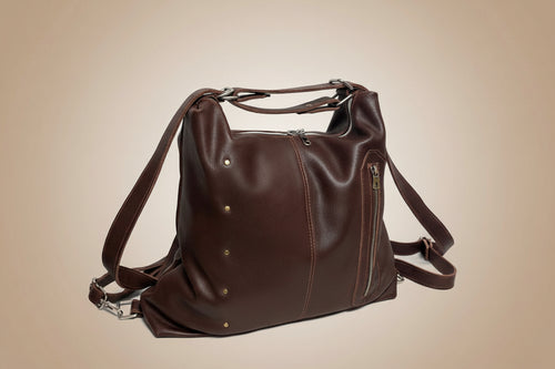 Brown leather bag with straps on a light gray background