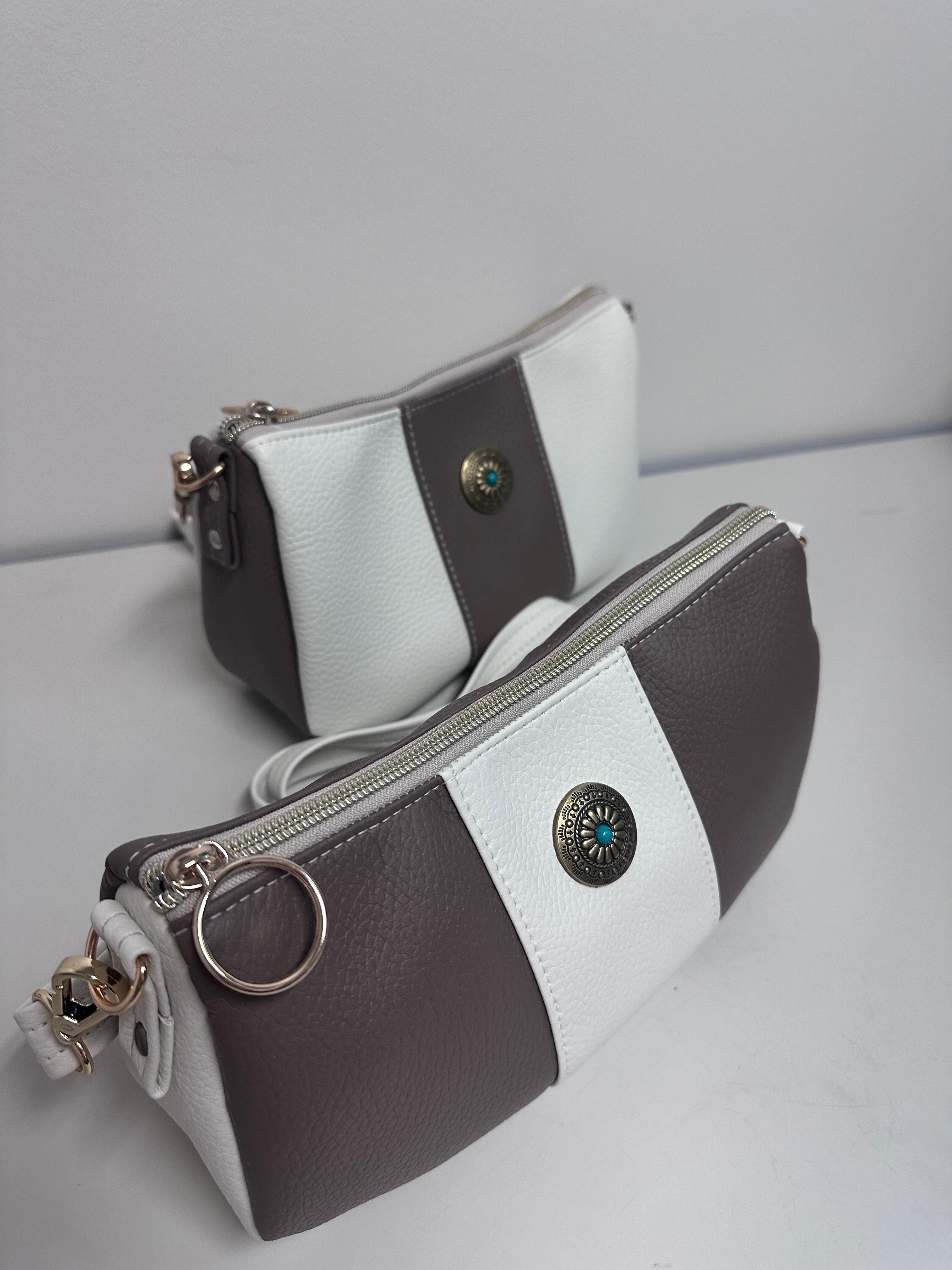 Two faux leather handbags, with decorative buttons on a light gray background.