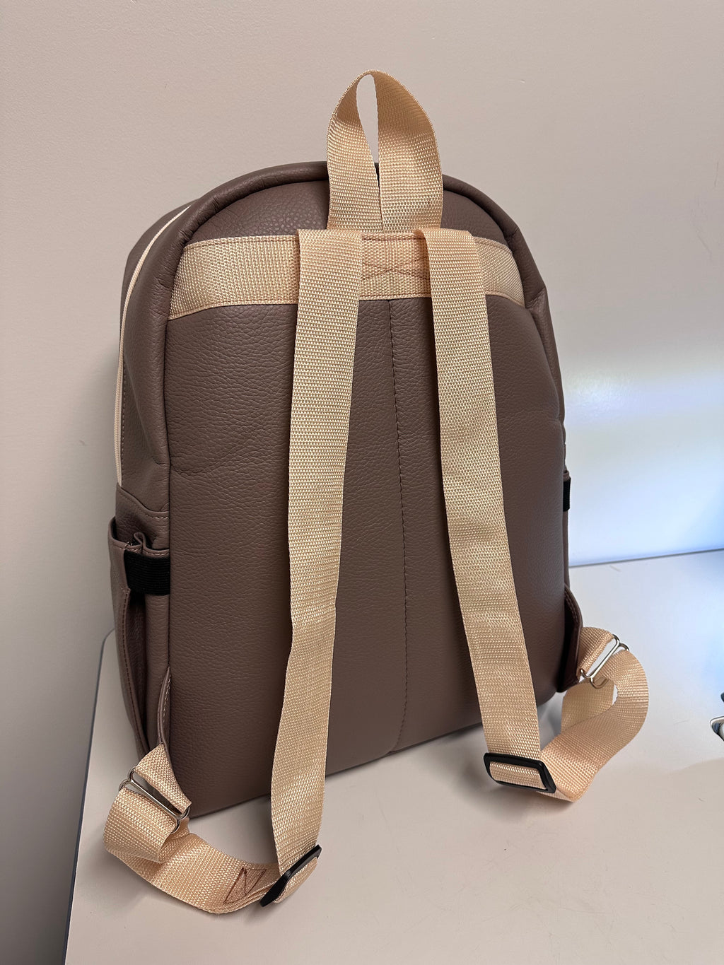 Brown bag with beige straps on a light gray background