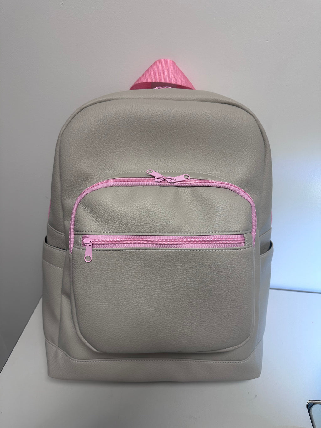 Gray backpack with pink zipper on a white background
