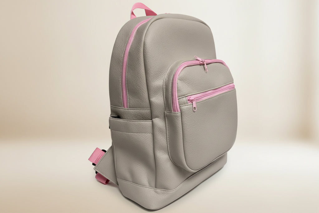 Gray backpack with pink zippers on a light gray background