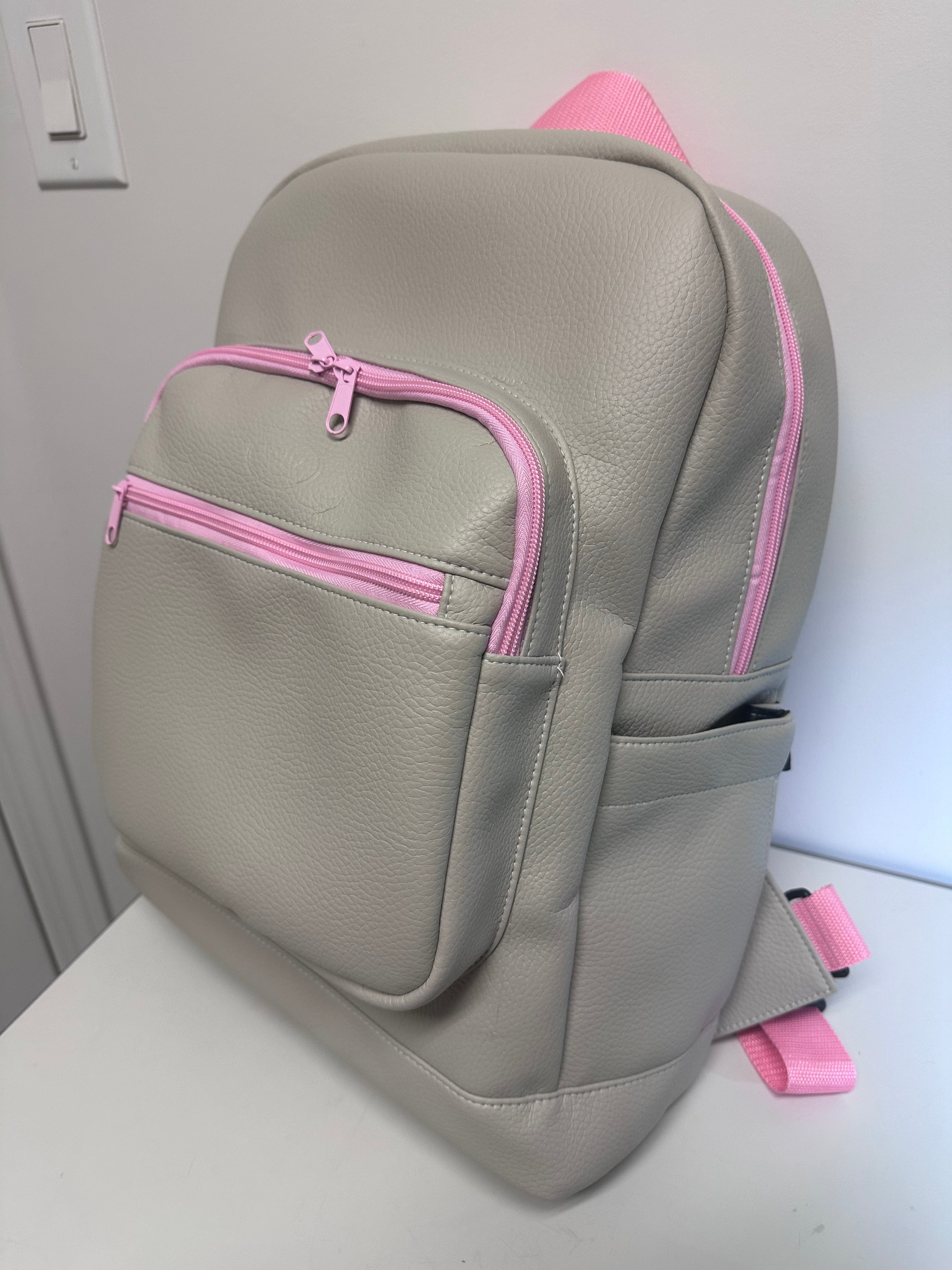 Gray bag with pink zippers on a light gray background